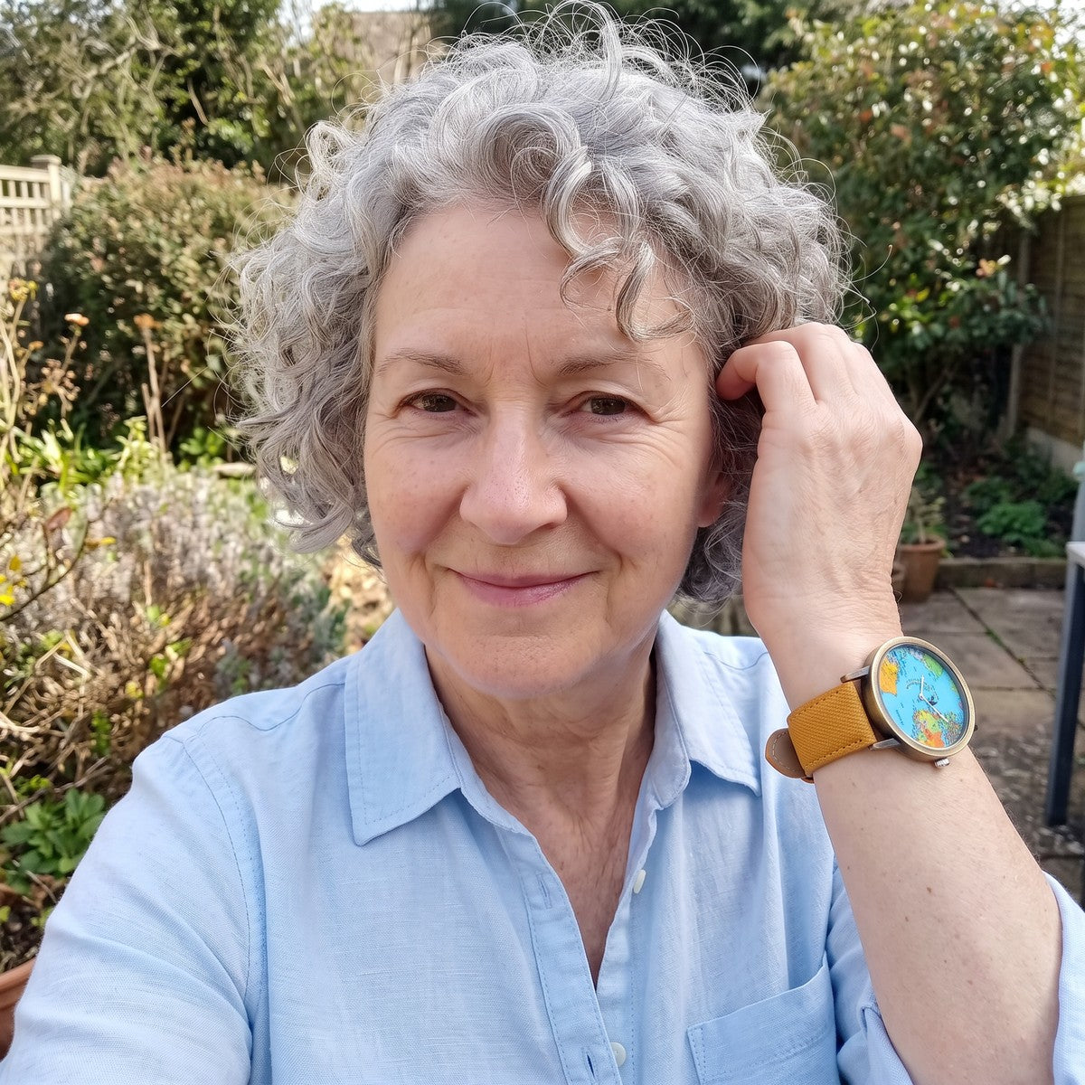 Woman in a home garden wearing a Yellow Skybound watch