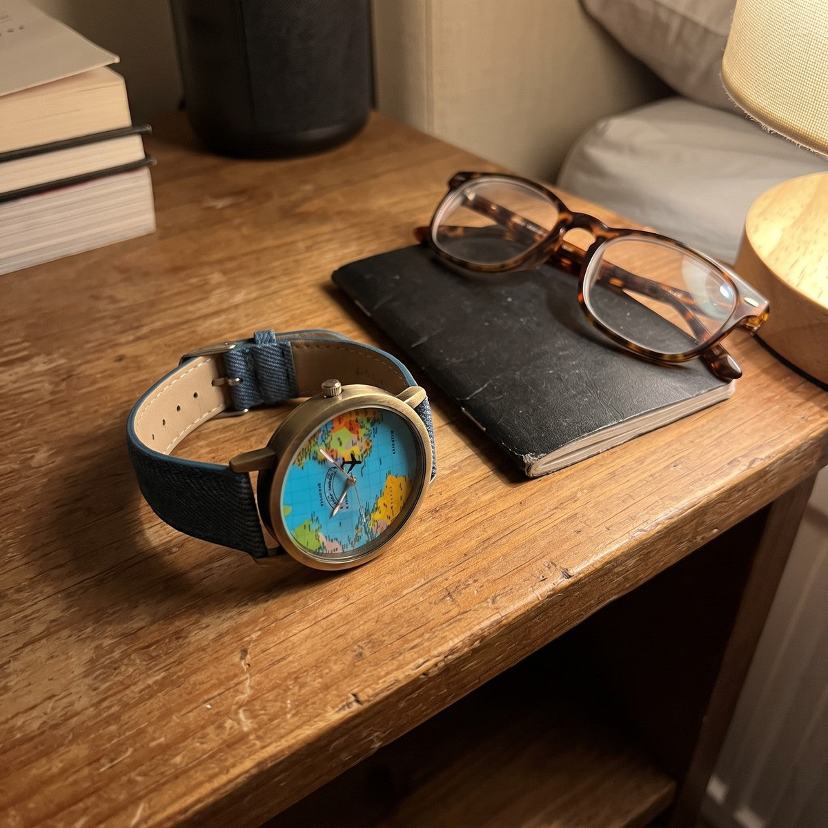 Blue Skybound watch beside a notebook on a bedside table