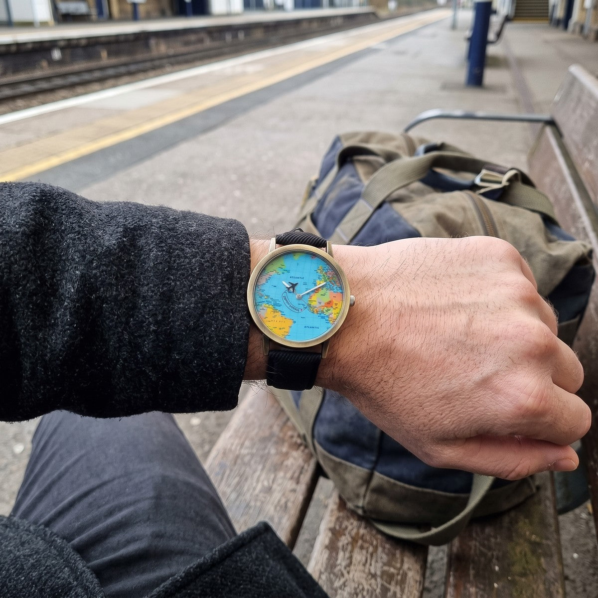 Man on a railway bench showing his Black Skybound watch